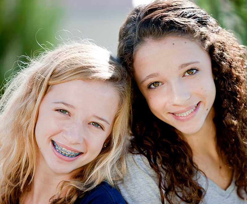 Two young girls smiling with braces