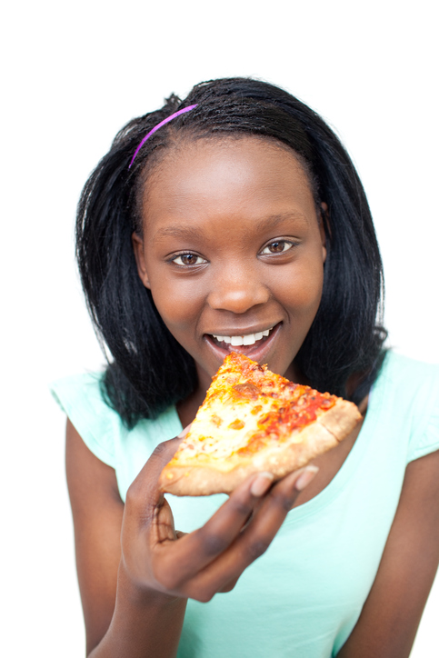 A young girl eating a banana smiling