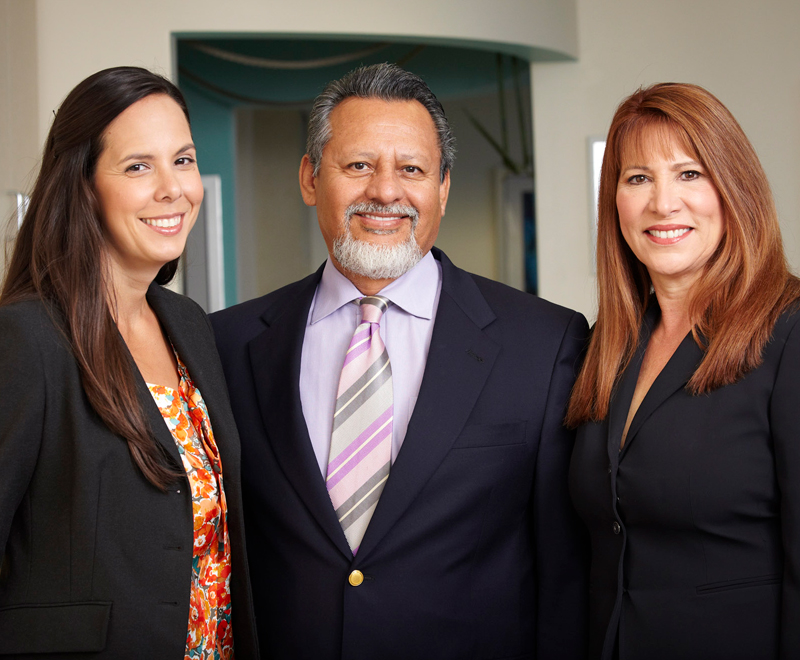 The 3 doctors dressed professionally, smiling
